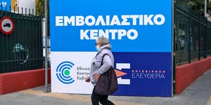 Γυναίκα με μάσκα σε εμβολιαστικό κέντρο 