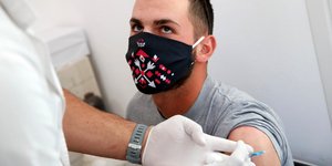 Νεαρός εμβολιάζεται κατά του κορωνοϊού