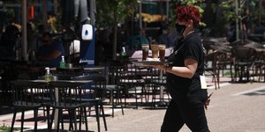 Εστίαση μια σερβιτόρα πηγαίνει ένα καφέ σε τραπέζι
