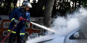 Πυροσβέστης σβήνει φωτιά σε αυτοκίνητο