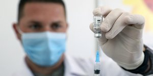 Γιατρός ετοιμάζει σύριγγα με το εμβόλιο Sinovac