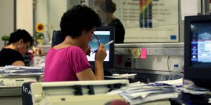 γυναίκα με γυαλιά στο Δημόσιο σε γραφείο μπροστά από υπολογιστή