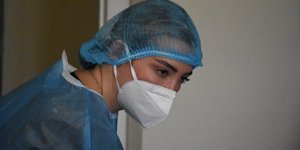 γυναίκα νοσηλεύτρια με στολή για προστασία από κορωνοϊό