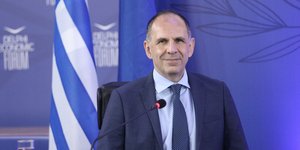 Ο Γιώργος Γεραπετρίτης χαμογελαστός μιλάει στο Φόρουμ των Δελφών