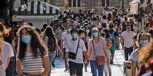 Πολίτες με μάσκες περπατούν στην Ερμού