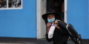 γυναίκα με μάσκα περπατά στην Κολομβία