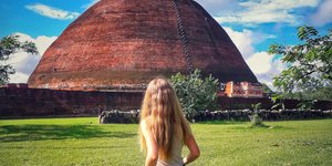 Κοπέλα με ποδήλατο περνά από την αρχαία πόλη Ανουρανταπούρα στη Σρι Λάνκα