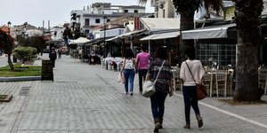 κόσμος περπατά σε πεζόδρομο έξω από μαγαζία