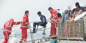 Μετανάστες εκ των οποίων ο ένας σε αναπηρικό μεταφέρονται από πλοίο στη στεριά από διασώστες