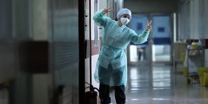 Υγειονομικός κάνει το σήμα της νίκης μέσα σε ΜΕΘ