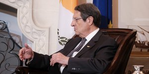 Νίκος Αναστασιάδης με κοστούμι σε καρέκλα