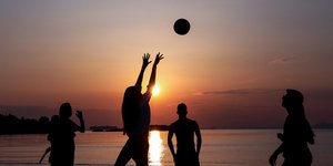 Κόσμος στην παραλία κατά το ηλιοβασίλεμα