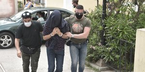 Δυο αστυνομικοί οδηγούν στο δικαστήριο τον 22χρονο σάτυρο με χειροπέδες και καλυμμένο κεφάλι