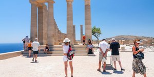 Τουρίστες βλέπουν τον αρχαίο ναό της Λίνδου στην Ρόδο και βγάζουν φωτογραφίες