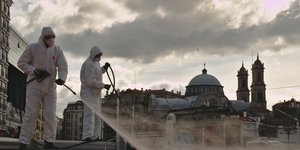 άνδρες απολυμαίνουν εξωτερικό χώρο στην Τουρκία λόγω κορωνοϊού