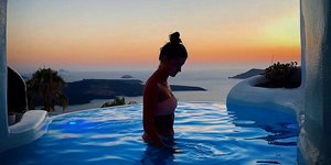 Γυναίκα κάνει μπάνιο σε πισίνα ξενοδοχείου Σαντορίνης