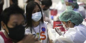 κόσμος με μάσκα σε εμβολιαστικό κέντρο στην Ταϊλάνδη