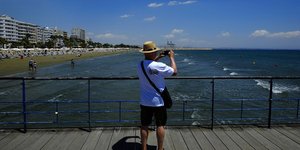 τουρίστας με καπέλο σε προβλήατα τραβάει φωτογαφία