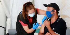 Άνδρας κάνει μια δόση του εμβολίου έναντι του κορωνοϊού