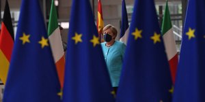 Η Άνγκελα Μέρκελ πίσω από σημαίες της ΕΕ, κατά τη Σύνοδο Κορυφής στις Βρυξέλλες