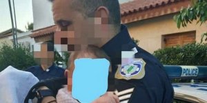 Ο αστυνομικός κρατάει στην αγκαλιά το ανήλικο παιδί της Καρολάιν