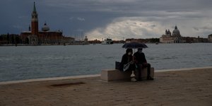 Ζευγάρι αγναντεύει τα κανάλια της Βενετία κάτω από τη βροχή, στην Ιταλία