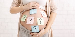 έγκυος με αυτοκόλλητα με ερωτηματικά στην κοιλιά
