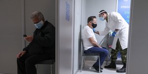 άνδρας εμβολιάζεται και άλλος ένας περιμένει