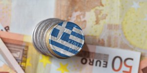 κέρμα με ελληνική σημαία και χαρτονομίσματα του ευρώ