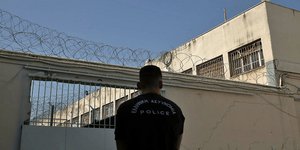 Ανδρας της ΕΛΑΣ μπροστά από πύλη φυλακών