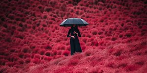 Γυναίκα κρατάει ομπρέλα μέσα σε ροζ λουλούδια