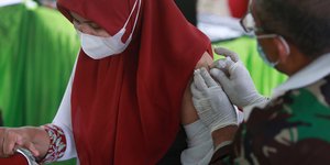 γυναίκα με μπούργκα και μάσκα κάνει εμβόλιο σε Ινδονησία