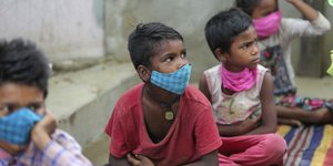 Παιδιά καθιστά με μάσκες στην Ινδία 