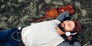 άνδρας ξαπλωμένος φορά ακουστικά