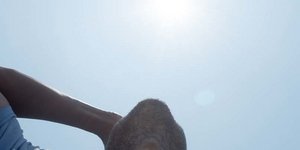 Άνδρας κοιτάζει ψηλά τον ήλιο