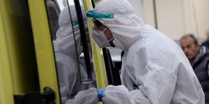 νοσηλευτής με στολή έξω από ασθενοφόρο