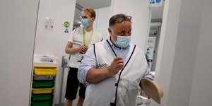 εμβόλιο κατά COVID-19 σε χέρια νοσηλευτή σε εμβολιαστικό κέντρο