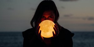 Γυναίκα κρατάει μια φωτισμένη μπάλα