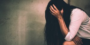 γυναίκα με λευκή ζακέτα και χέρι στο κεφάλι μετά από επίθεση