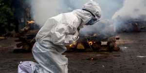 Γυναίκα με στολή προστασίας από τη μετάδοση του κορωνοϊού σε χώρο καύσης νεκρών