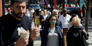 Πολίτες στο κέντρο του Λονδίνου, ορισμένοι με μάσκες προστασίας για τον κορωνοϊό