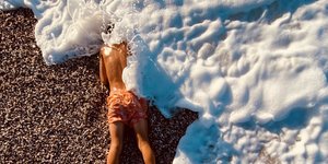 αγόρι καλύπτεται από κύμα σε παραλία