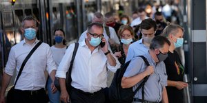 Επιβάτες με μάσκες σε σταθμό τρένου στο Λονδίνο