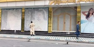 Άνδρας βάφει αφίσα γυναικείου μοντέλου στην Καμπούλ