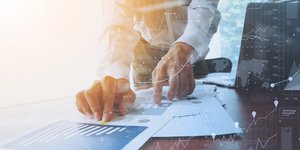 άνδρας μελετά χαρτιά επιχείρησης σε γραφείο