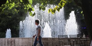 Άνδρας μπροστά από συντριβάνι στην Αθήνα κατά τη διάρκεια του καύσωνα