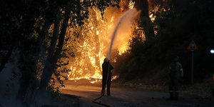 Πυροσβέστης σβήνει φλόγες στην Βαρυμπόμπη