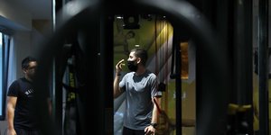 Άνδρας με μάσκα σε αίθουσα γυμναστηρίου