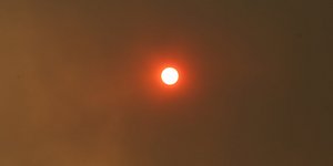 Ο ήλιος κρυμμένος πίσω από τους καπνούς της Αττικής