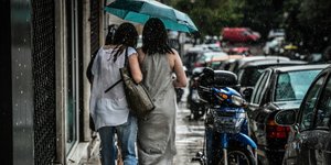 κοπέλες ομπρέλα περπατούν πεζοδρόμιο βροχή